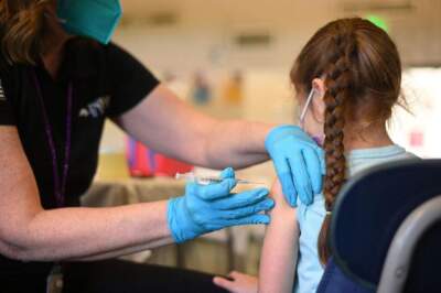 A nurse administers a pediatric dose of the Covid-19 vaccine to a girl at a L.A. Care Health Plan vaccination clinic at Los Angeles Mission College, January 19, 2022. (Photo by ROBYN BECK/AFP via Getty Images)