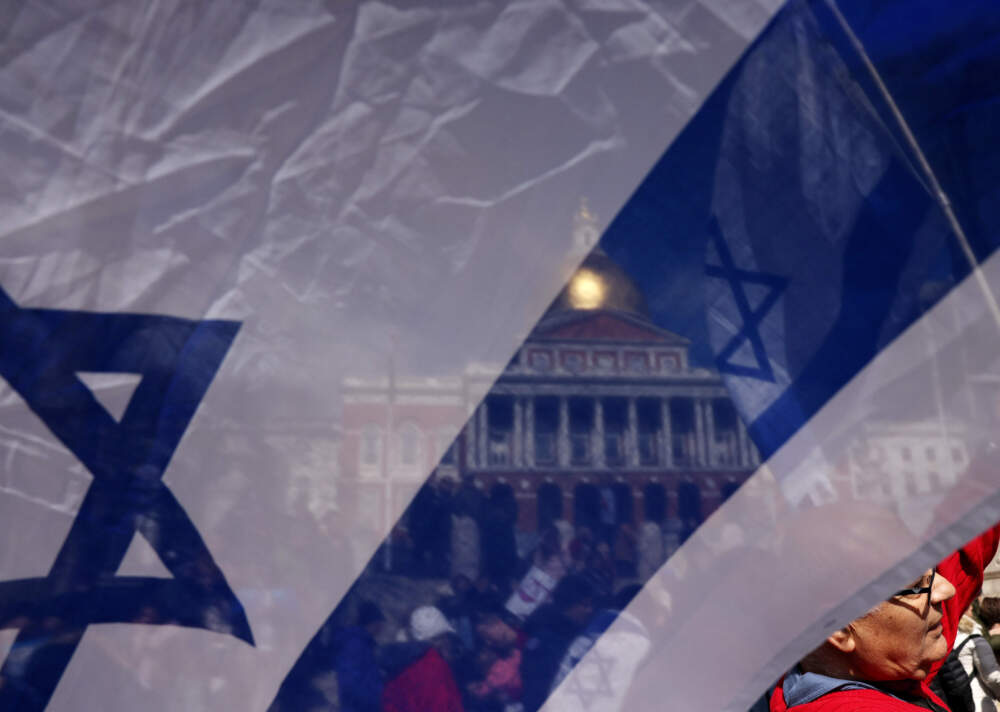 Boston, MA - March 12: A man held an Israeli flag as he and fellow protesters gathered on the Boston Common to defend democracy in Israel. (Photo by Jessica Rinaldi/The Boston Globe via Getty Images)