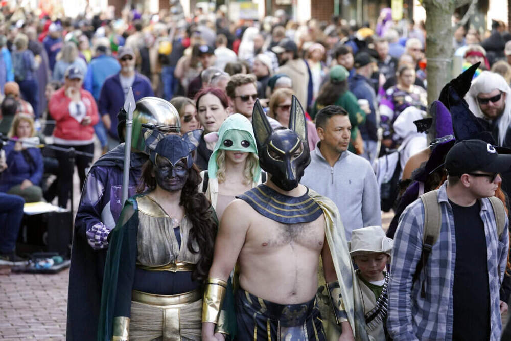 People dressed in a variety of costumes promenade through downtown Salem, Mass., on Halloween in 2021. (Steven Senne/AP)