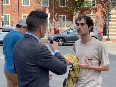 Jeremy Ornstein (right), a Harvard senior, argues with Adam Guillette on Mass. Ave. (Max Larkin/WBUR)