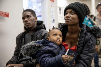 Rose Juliane Charles waits with her husband Lucson and daughter Sarah at the Immigrant Family Services Institute, in Mattapan, as they try to figure out where to spend the night. (Robin Lubbock/WBUR)