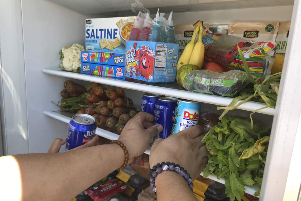Volunteers stock a refrigerator with free food for people in need in Los Angeles. (Aron Ranen/AP)