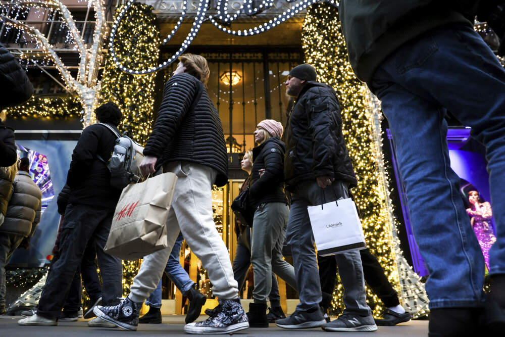 Shoppers carry bags down Fifth Avenue. (Julia Nikhinson/AP)