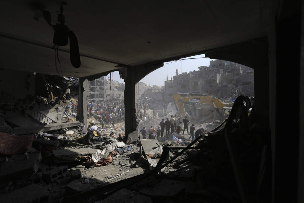 Palestinians work among debris of buildings that were targeted by Israeli airstrikes in Jabaliya refugee camp. (Abed Khaled/AP)