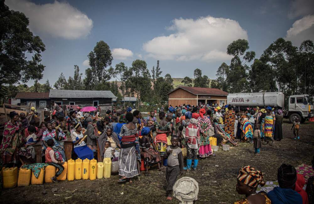 Internal displaced people, fleeing the recent clashes between M23 rebels and Congolese soldiers, queue queue to collect water from a water tank in Kanyarushinya north of Goma on May 27, 2022. (Aubin Mukoni/AFP via Getty Images)