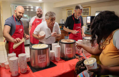 Volunteers scoop ice cream during an ice cream social at the Catholic Charities Inn the largest assistance shelter run by Catholic Charities of Boston. (Photo by Matthew J. Lee/The Boston Globe via Getty Images)