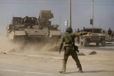 A soldier gives directions to a tank unit near the border with Gaza on October 14, 2023 near Sderot, Israel. Israel has sealed off Gaza and launched sustained retaliatory air strikes, which have killed at least 1,400 people with more than 400,000 displaced, after a large-scale attack by Hamas. On October 7, the Palestinian militant group Hamas launched a surprise attack on Israel from Gaza by land, sea, and air, killing over 1,300 people and wounding around 2,800. Israeli soldiers and civilians have also been taken hostage by Hamas and moved into Gaza. The attack prompted a declaration of war by Israeli Prime Minister Benjamin Netanyahu and the announcement of an emergency wartime government. (Photo by Amir Levy/Getty Images)