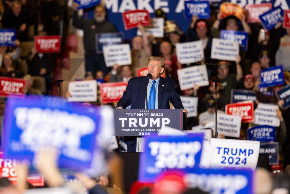 A supporter of Republican presidential candidate former President Donald Trump hold up signs as he delivers remarks at a campaign event on Nov. 11, 2023 in Claremont, New Hampshire. (Scott Eisen/Getty Images)
