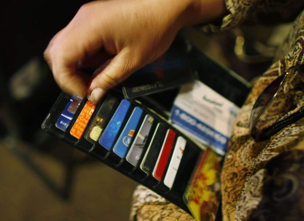 A woman looks in her wallet for credit cards. (Joe Raedle/Getty Images)
