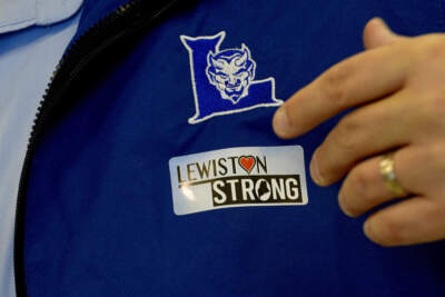 School Superintendent Jake Langlais applies a Lewiston Strong sticker to his jacket Oct. 31, 2023. (Matt York/SP)