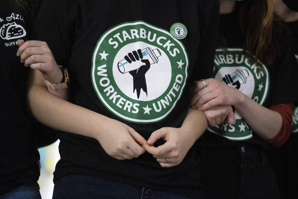 Starbucks employees and supporters link arms during a union election watch party Dec. 9, 2021, in Buffalo, N.Y. (Joshua Bessex/AP)