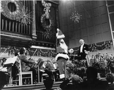 Arthur Fiedler onstage during a Holiday Pops concert with Santa Claus in 1977. (Courtesy BSO Archives)