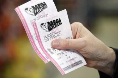 A customer at a convenience store holds her Mega Millions lottery tickets in 2012 in Portland, Ore. (Rick Bowmer/AP)