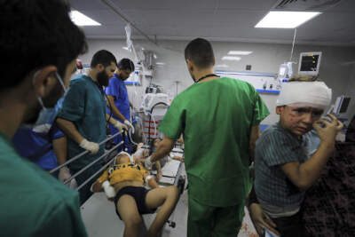 A Palestinian medic treats wounded people in the Israeli bombardment at Shifa Hospital in Gaza City on Oct. 23. (Yasser Qudih/AP)