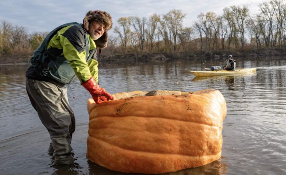 David Rothstein of Florence, Massachusetts, prepares to set off from Hatfield on day three of his attempt to secure the world record for distance traveled in a pumpkin. His friend, John Frey, waiting in a kayak, will accompany him on this leg of the journey. (Ben James/NEPM)