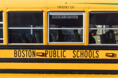 A student looks out the window of a school bus on Malcom X Boulevard in Roxbury. (Jesse Costa/WBUR)