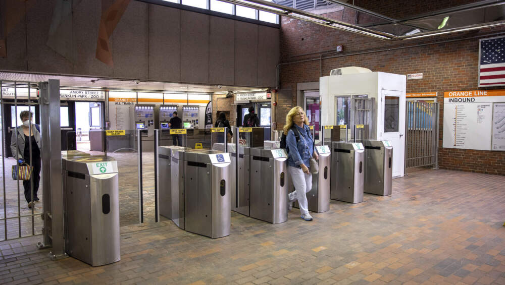 A passenger walks through a fare gate at the MBTA's Green Street station. (Robin Lubbock/WBUR)
