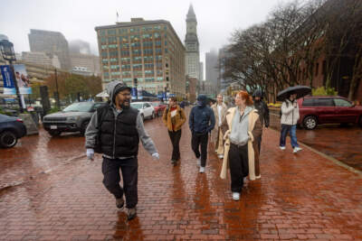 Joel Mackall leads a group of students from the University of London down Long Wharf during one of his Hidden Black History Tours. (Jesse Costa/WBUR)