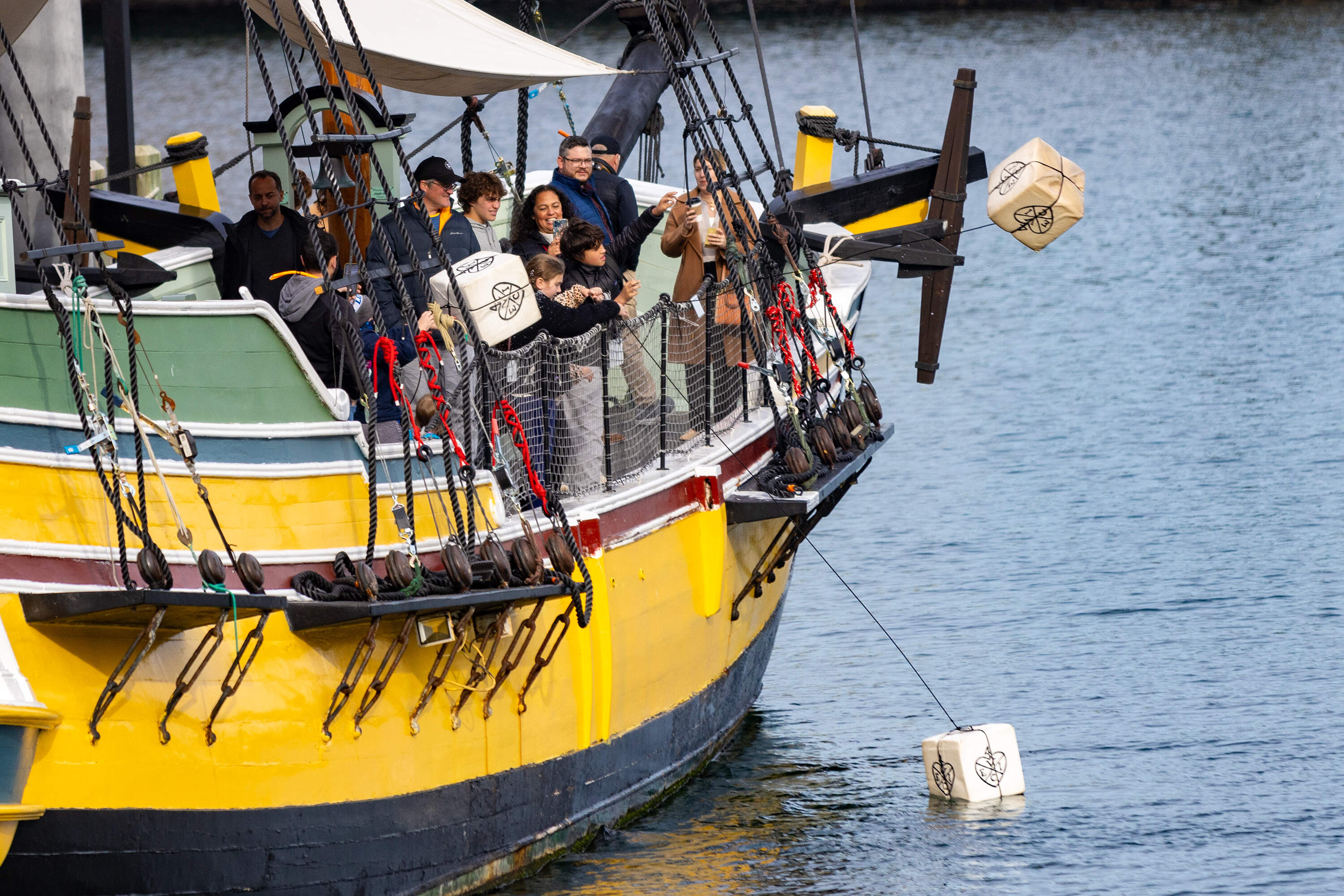 Crates splash into the Fort Point Channel after being tossed overboard by three young museum goers from the merchant vessel Eleanor during a visit to the Boston Tea Party Museum. (Jesse Costa/WBUR)