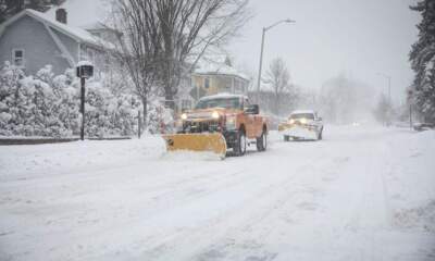 A snow plow drives down a residential street in Cambridge. (Robin Lubbock/WBUR)