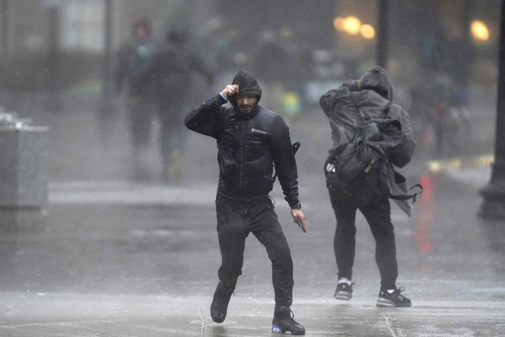 Pedestrians are buffeted by wind and rain as they cross a street on Monday in Boston. (Steven Senne/AP)