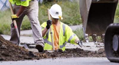 Utility contractors dig up the road above natural gas lines along Dracut Street in Lawrence, Mass. (Charles Krupa/AP)