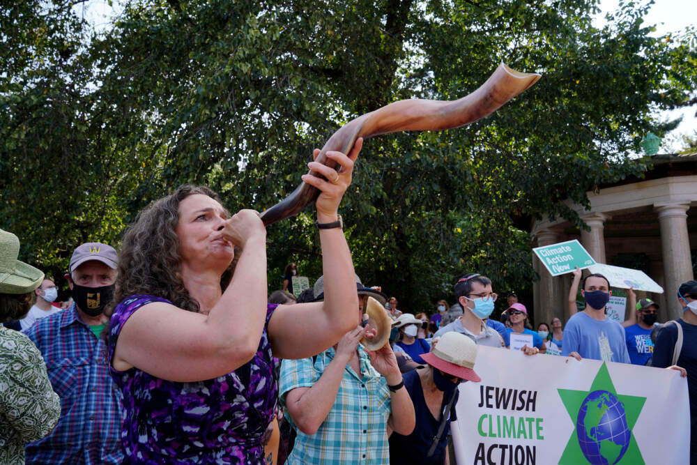 Rabbi Jennie Rosenn, Founder and CEO of Dayenu, blows the shofar at a Jewish climate action in Brooklyn, N.Y., in 2021. &quot;Hear the Call&quot; events brought activists to the doorsteps of U.S. senators at 16 locations across the country in the weeks leading up to the Jewish High Holidays. (Courtesy Jemal Countess for Dayenu)