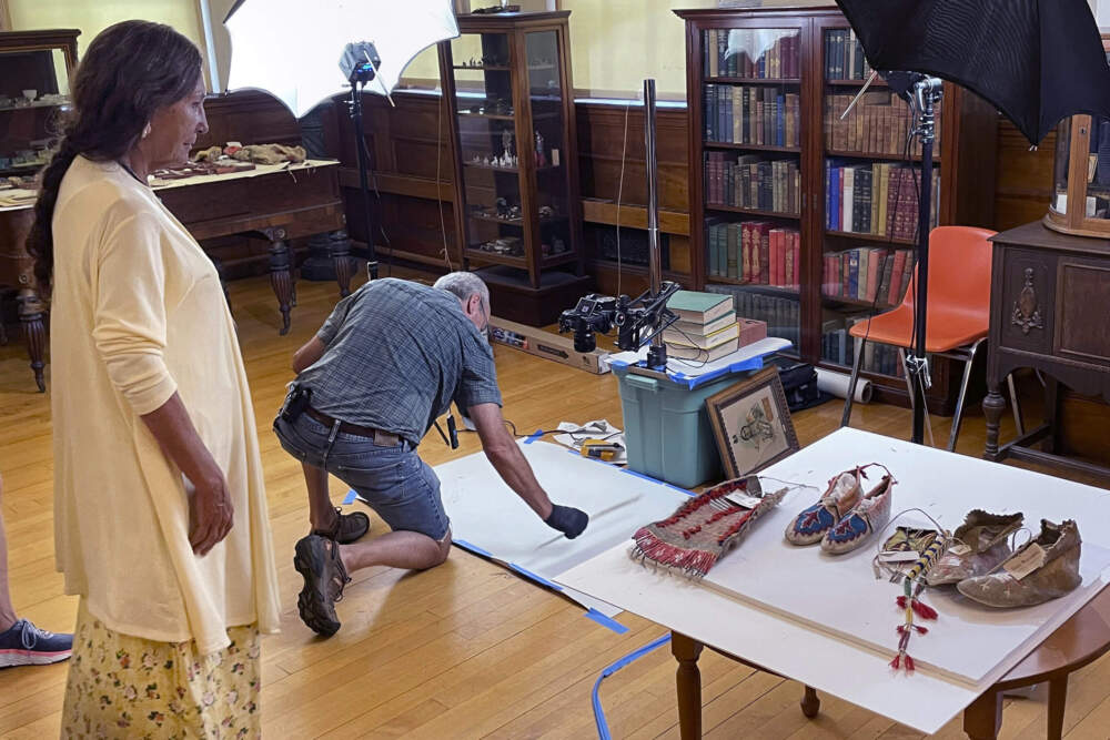 Leola One Feather, left, of the Oglala Sioux Tribe in South Dakota, observes as John Willis photographs Native American artifacts on July 19, 2022, at the Founders Museum in Barre, Mass. ahead of a repatriation of the objects. (Philip Marcelo/AP)