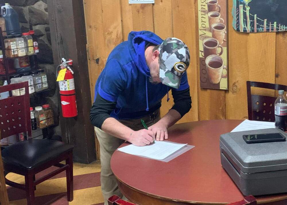 Gary Bird, president of the board at Bissellville Estates, signs a document in favor of the resident purchase of a mobile home park in Hinsdale. (Courtesy)
