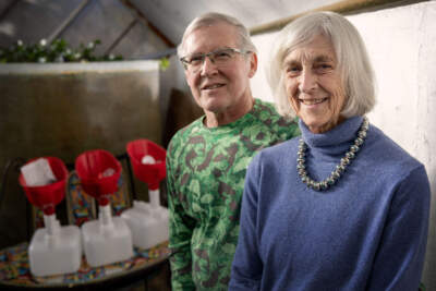 Earle Barnhart and Hilda Maingay in their greenhouse, where three cubies are on show and available for purchase. (Robin Lubbock/WBUR)