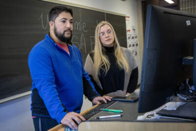 Fernando Garcia-Rodriguez, assistant director of Mount Wachusett Community College Educational Opportunity Center, and Cassie Peltola a community outreach counselor, look at FAFSA online application form. (Robin Lubbock/WBUR)
