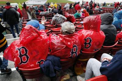 Fans at Fenway Park wait out a rain delay before a baseball game between the Boston Red Sox and the Los Angeles Angels, Monday, April 17, 2023, in Boston. (Michael Dwyer/AP)