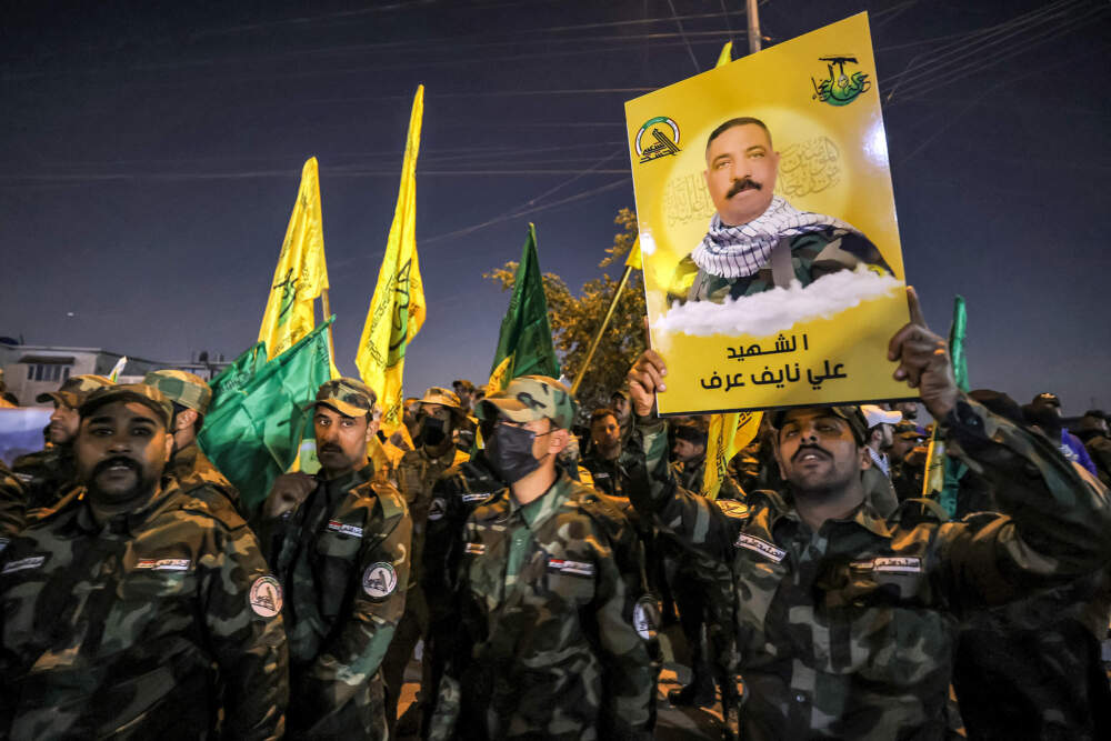 A member of Iraq's Popular Mobilisation Forces (PMF) paramilitaries holds a sign identifying one of the group's slain members during the funeral at the PMF headquarters in Baghdad on Jan. 4, 2024. A U.S. strike in Baghdad on January 4 killed a military commander of the PMF, an ex-paramilitary faction of the grouping said, with an Iraqi security official reporting two deaths in a drone attack. Harakat al-Nujaba, one of the PMF's factions, said in a statement that &quot;the deputy commander of operations for Baghdad, Mushtaq Talib al-Saidi&quot;, had been &quot;martyred in a US strike&quot;. (Ahmad Al-Rubaye/AFP via Getty Images)