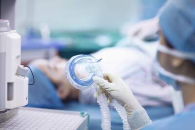 A nurse holds an anesthesia mask in an operating room. (Shannon Fagan/Getty Images)