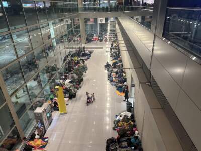 Dozens of migrant families sleep at Logan Airport as they wait for permanent shelter. (Gabrielle Emanuel/WBUR)