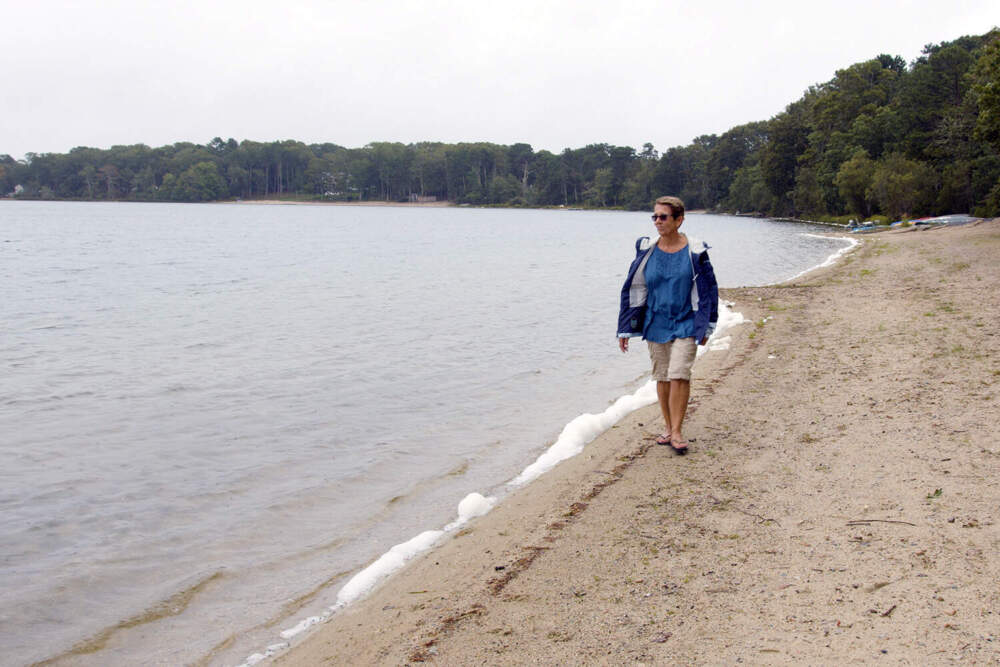 Pat Uhlman on the shore of Shubael Pond in Barnstable, Mass. The pond was closed for most of summer, 2019, because of a toxic algal bloom. (Duy Linh Tu/Sebastian Tuinder for Scientific American)