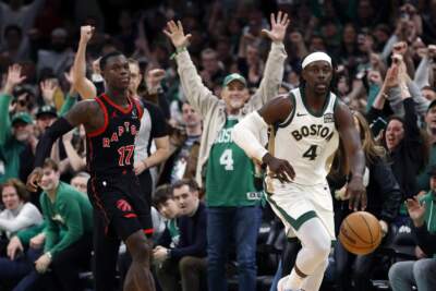Fans react behind Boston Celtics' Jrue Holiday and Toronto Raptors' Dennis Schroder. (Michael Dwyer/AP)