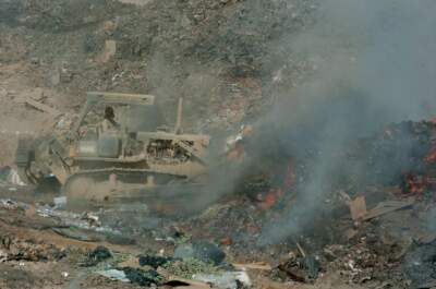 In a 2004 photo, Army Sgt. Richard Ganske uses a bulldozer to maneuver trash into a burn pit in Balad, Iraq. Burn pits were common at U.S. military outposts in Iraq and Afghanistan, where troops incinerated tons of waste every day. (Abel Trevino/U.S. Army)