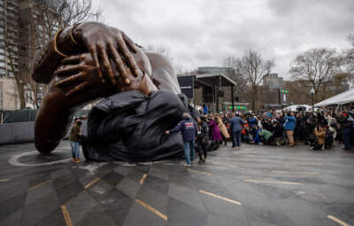 Dignitaries and guests approach the Embrace on Boston Common as staff unveil the sculpture. (Robin Lubbock/WBUR)