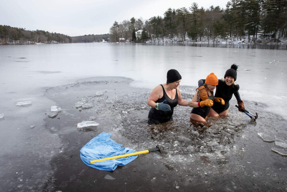 Sally Milliken, Claire Smith and Cognoscenti contributor Libby DeLana, far right, make their way out of the icy water at Stiles Pond in Boxford, Mass. (Robin Lubbock/WBUR)