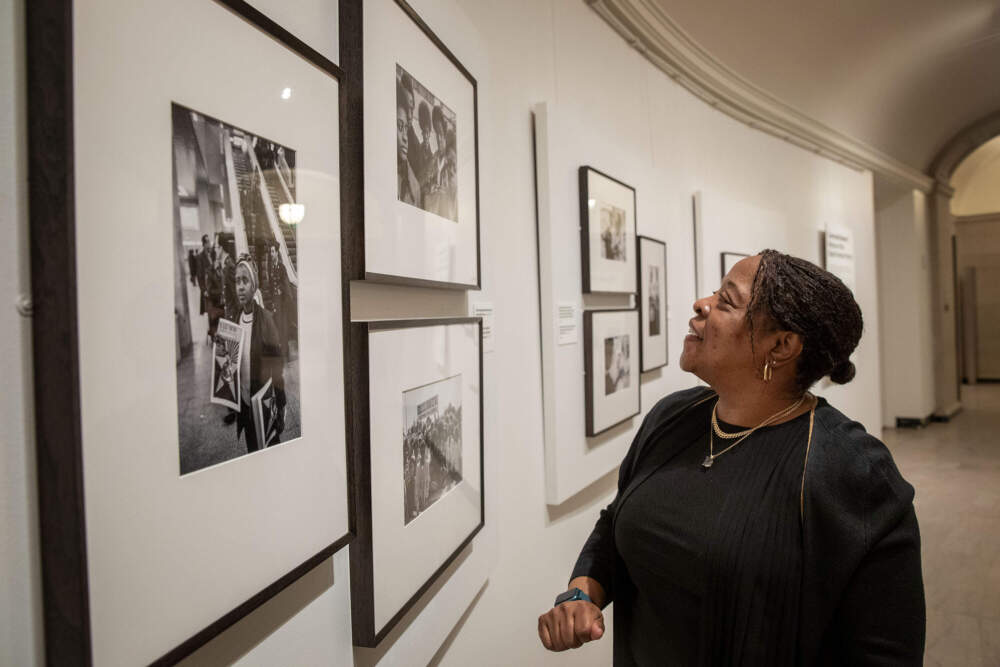 Gail Jones looks at a 1970 photograph by Stephen Shames of herself with her siblings and two friends, in the MFA Boston's "Comrade Sisters: Women of the Black Panther Party" exhibit. (Robin Lubbock/WBUR)