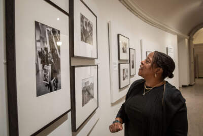 Gail Jones looks at a 1970 photograph by Stephen Shames of herself with her siblings and two friends, in the MFA Boston's &quot;Comrade Sisters: Women of the Black Panther Party&quot; exhibit. (Robin Lubbock/WBUR)