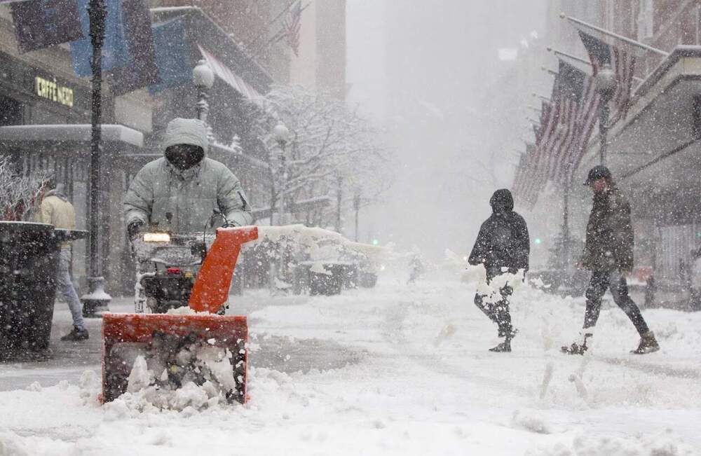 In the middle of the storm, a snowblower keeps sidewalks clear on Summer St. in 2018. (Robin Lubbock/WBUR)