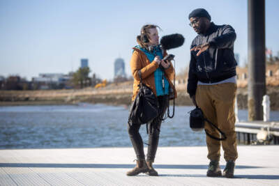 The Common host Darryl C. Murphy and podcast producer Katelyn Harrop record some audio for the show from a Boston Harbor dock. (Robin Lubbock/WBUR)