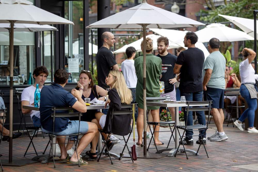 People at tables on the sidewalk at lunchtime by Kava Neo-Taverna on Shawmut Avenue in Boston. (Robin Lubbock/WBUR)