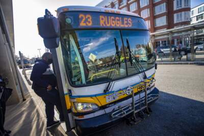 Riders board the 23 Ruggles bus at Ashmont Station, one of the three bus routes that offer fare-free service in Boston. (Jesse Costa/WBUR)