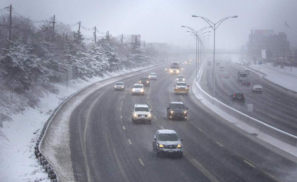 Cars drive down the Mass Pike during a snowstorm in 2019. (Robin Lubbock/WBUR)