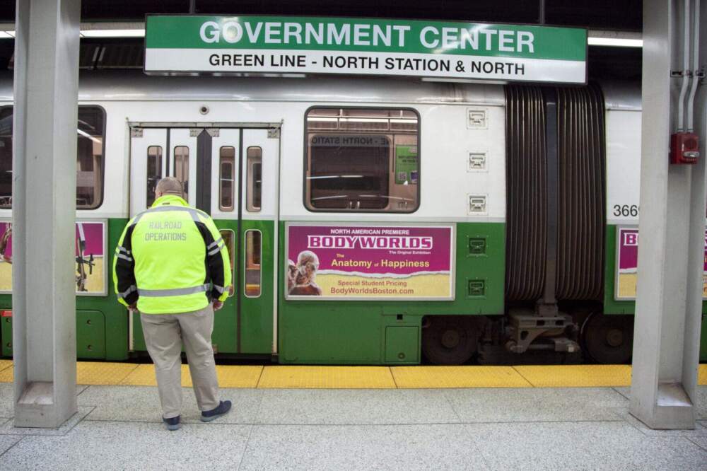 An MBTA official surveys a Green Line train at Government Center station on Feb. 15, 2024. (Chris Lisinski/SHNS)