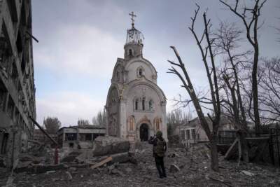 A Ukrainian serviceman takes a photograph of a damaged church after shelling in a residential district in Mariupol, Ukraine. (Evgeniy Maloletka/AP)