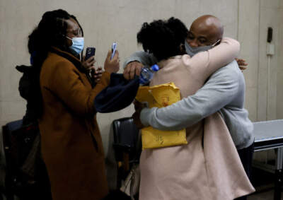 James Lucien (right) is embraced by a family member as he walks out of Suffolk Superior Court in Boston as a free man on December 7, 2021. (Jessica Rinaldi/The Boston Globe via Getty Images)